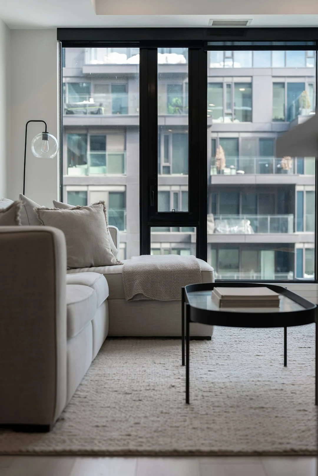 A couple straightening up their living room, arranging furniture and rugs together as a team.